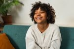 Beautiful african american girl with afro hairstyle smiling. Close up portrait of young happy girl. Young african woman with curly hair laughing. Freedom happiness carefree happy people concept.
