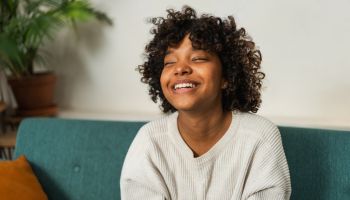Beautiful african american girl with afro hairstyle smiling. Close up portrait of young happy girl. Young african woman with curly hair laughing. Freedom happiness carefree happy people concept.