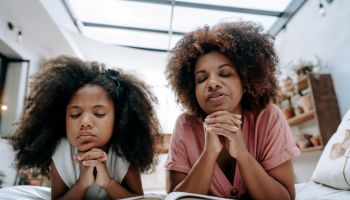 Mother teaches daughter to pray