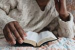 Woman Reads Bible in Bed