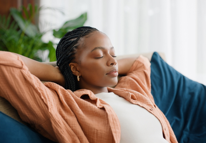Black woman, relax and sleeping on sofa with dream of future investment in home or living room. Person with eyes closed on her couch or lounge for break, peace and security of house, mortgage or rent
