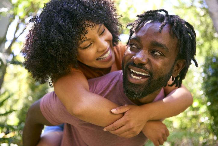 spin the block - Loving Mid Adult Couple Outdoors In Summer Garden Or Countryside With Man Giving Woman Piggyback