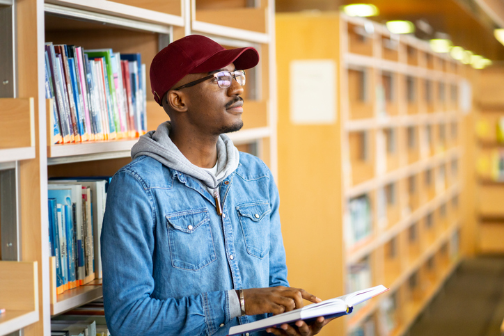 Male student with a reference book