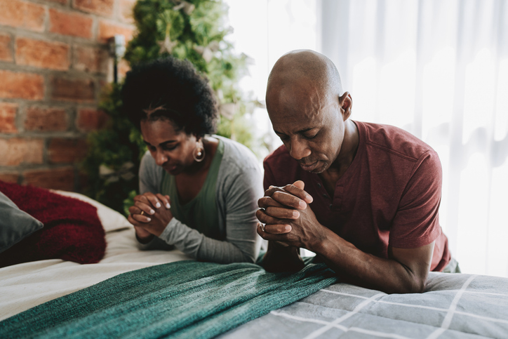How to Pray for Your Future Spouse - Couple praying kneeling on the bed in the bedroom
