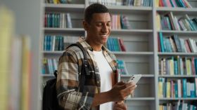 African American man guy user mobile phone smartphone cellphone network student study educational bookcase bookstore library internet wifi online university archive high school browser literature male