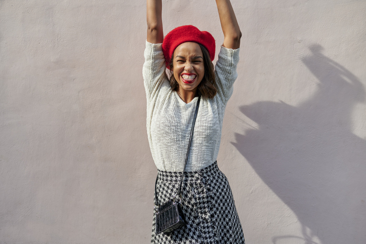 Portrait of smiling woman with red beret with simple background.